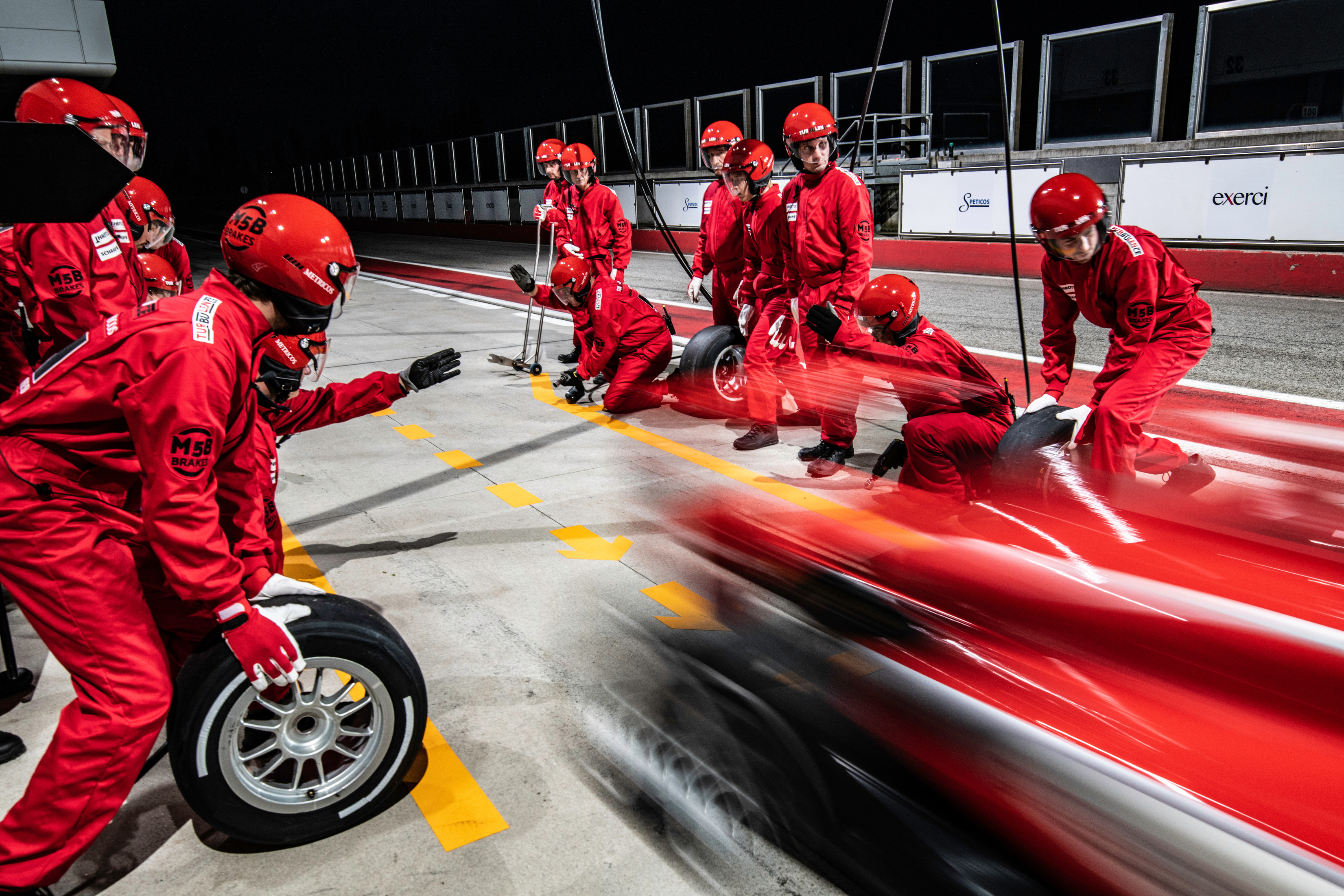 Red formula race car leaving the pit stop